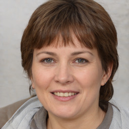 Joyful white adult female with medium  brown hair and grey eyes