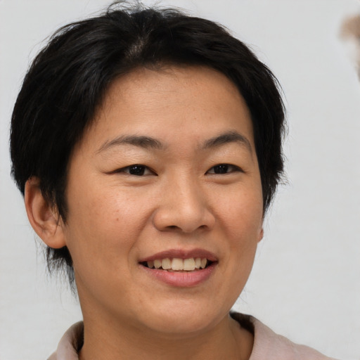 Joyful asian adult female with short  brown hair and brown eyes