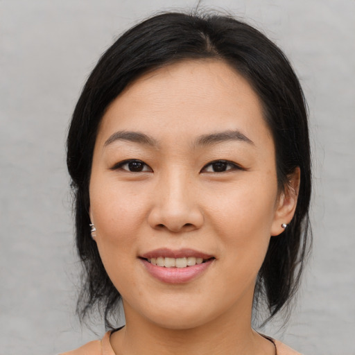 Joyful asian young-adult female with medium  black hair and brown eyes