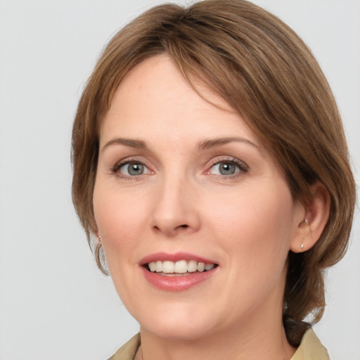 Joyful white young-adult female with medium  brown hair and grey eyes