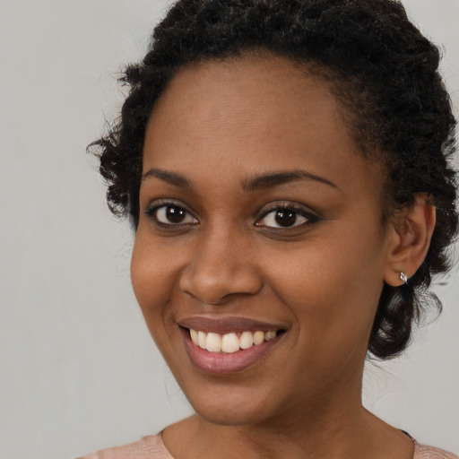 Joyful black young-adult female with short  brown hair and brown eyes
