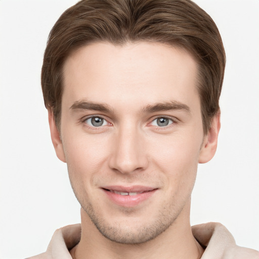 Joyful white young-adult male with short  brown hair and grey eyes