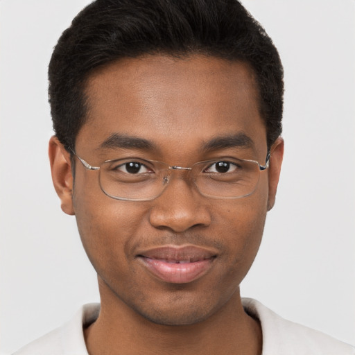 Joyful black young-adult male with short  brown hair and brown eyes