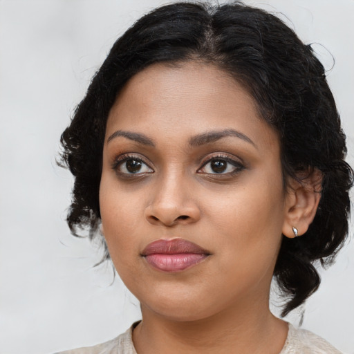 Joyful black young-adult female with medium  brown hair and brown eyes