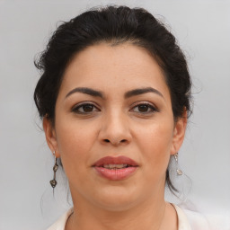 Joyful latino adult female with medium  brown hair and brown eyes