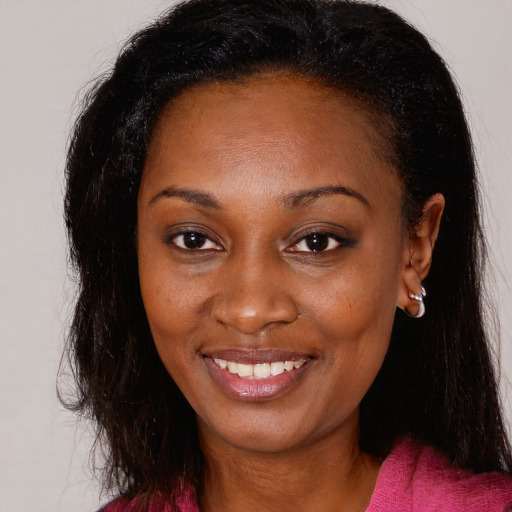 Joyful black young-adult female with long  brown hair and brown eyes