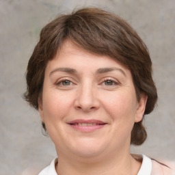 Joyful white young-adult female with medium  brown hair and grey eyes