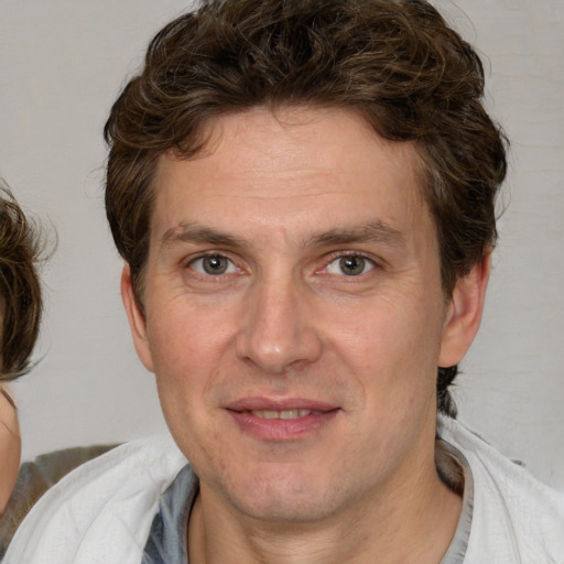 Joyful white adult male with medium  brown hair and brown eyes