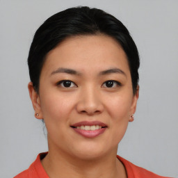 Joyful asian young-adult female with short  black hair and brown eyes