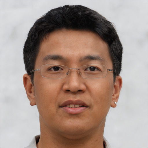 Joyful asian adult male with short  brown hair and brown eyes