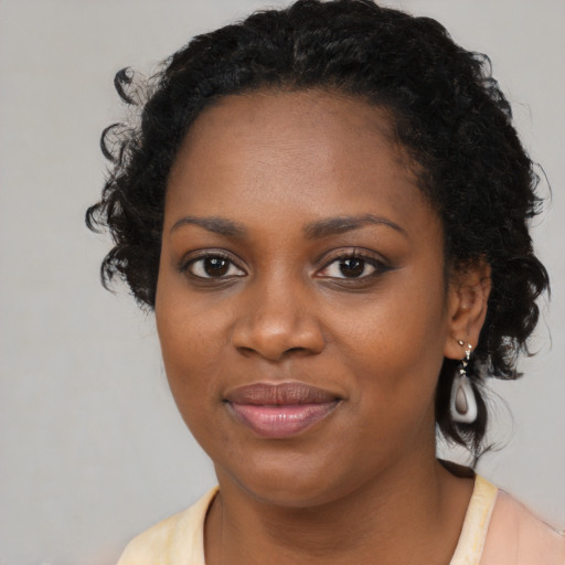 Joyful black young-adult female with medium  black hair and brown eyes