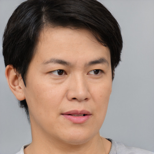 Joyful asian young-adult female with short  brown hair and brown eyes