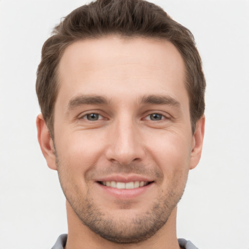 Joyful white young-adult male with short  brown hair and grey eyes