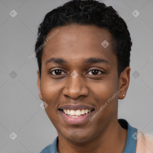 Joyful black young-adult male with short  black hair and brown eyes