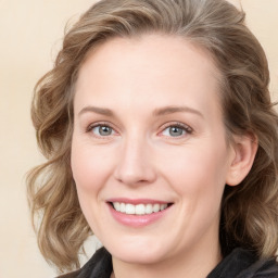 Joyful white young-adult female with medium  brown hair and blue eyes