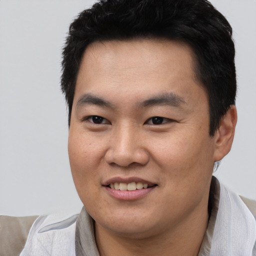 Joyful asian young-adult male with short  black hair and brown eyes
