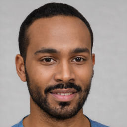 Joyful black young-adult male with short  brown hair and brown eyes