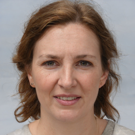 Joyful white adult female with medium  brown hair and blue eyes