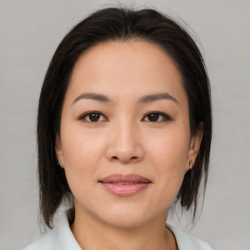 Joyful asian young-adult female with medium  brown hair and brown eyes