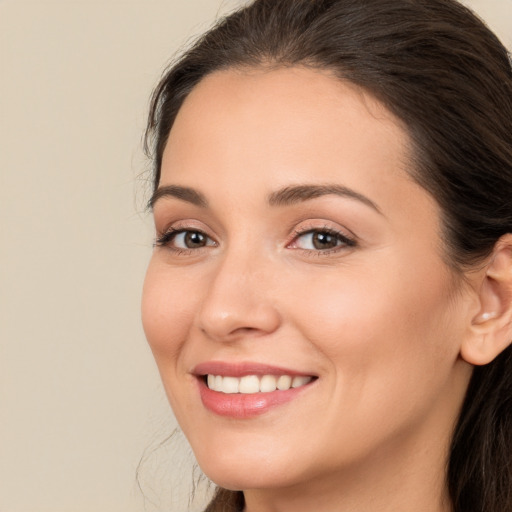 Joyful white young-adult female with long  brown hair and brown eyes