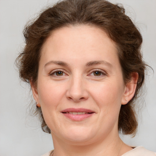 Joyful white young-adult female with medium  brown hair and green eyes