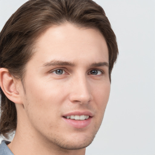 Joyful white young-adult male with medium  brown hair and grey eyes