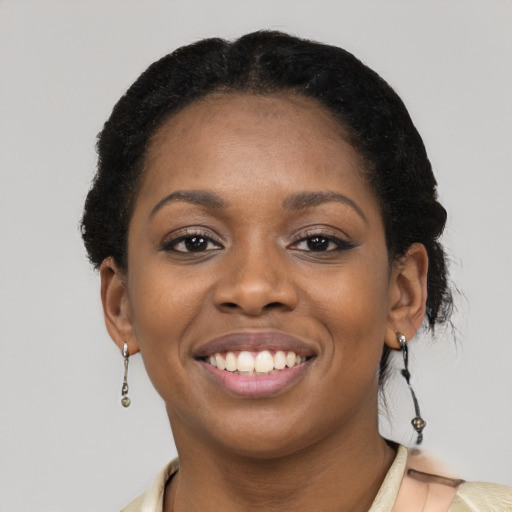 Joyful black young-adult female with short  black hair and brown eyes