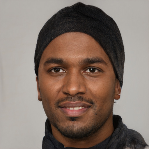 Joyful black young-adult male with short  black hair and brown eyes