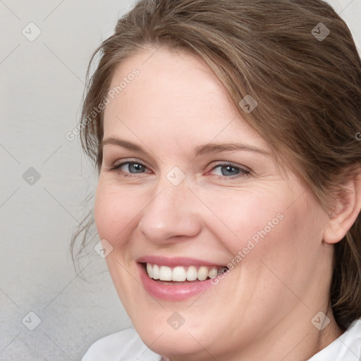 Joyful white adult female with medium  brown hair and blue eyes