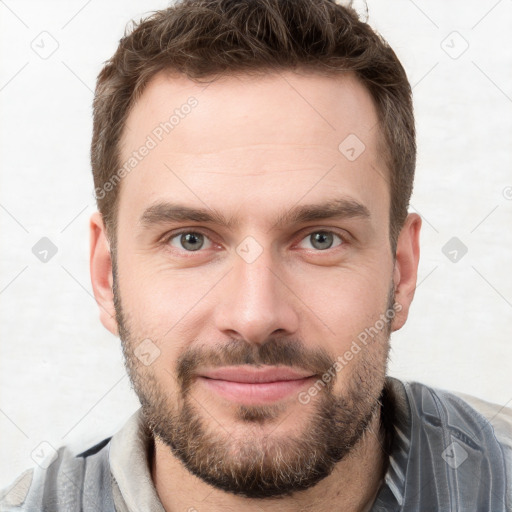 Joyful white young-adult male with short  brown hair and grey eyes