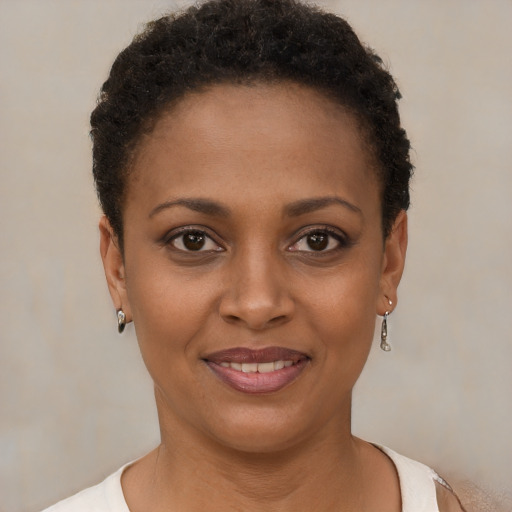Joyful black young-adult female with short  brown hair and brown eyes
