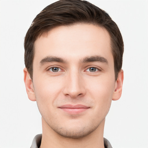 Joyful white young-adult male with short  brown hair and grey eyes