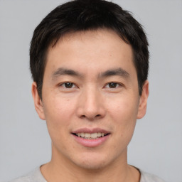 Joyful asian young-adult male with short  brown hair and brown eyes