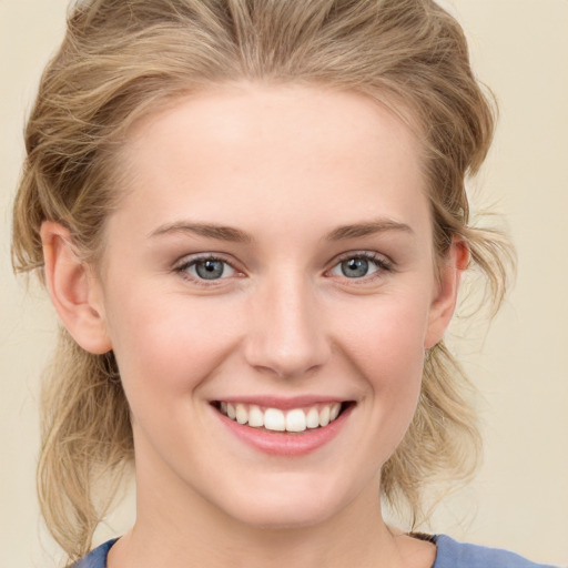 Joyful white young-adult female with medium  brown hair and blue eyes