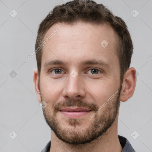 Joyful white young-adult male with short  brown hair and grey eyes