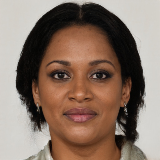 Joyful black adult female with medium  brown hair and brown eyes