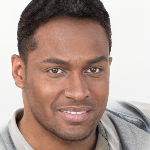 Joyful black young-adult male with short  brown hair and brown eyes