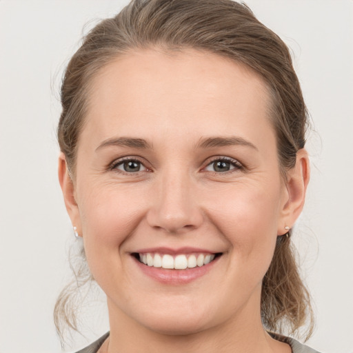 Joyful white young-adult female with medium  brown hair and grey eyes