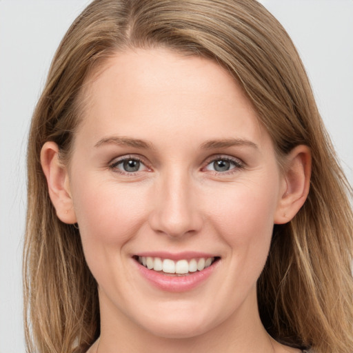 Joyful white young-adult female with long  brown hair and grey eyes