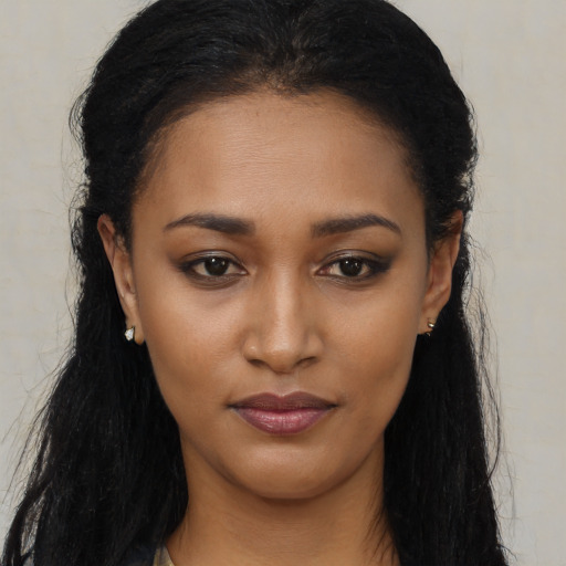 Joyful black young-adult female with long  black hair and brown eyes
