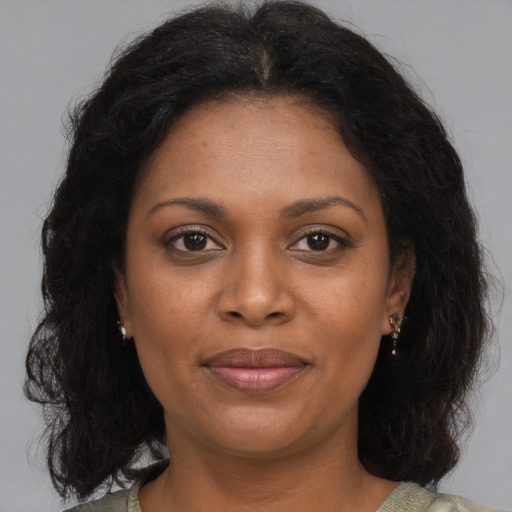 Joyful black adult female with medium  brown hair and brown eyes