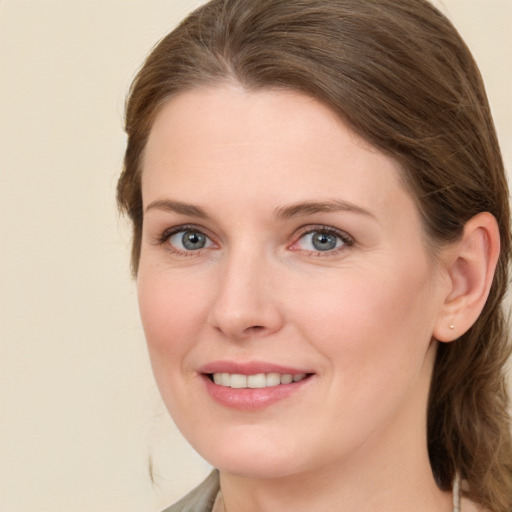 Joyful white young-adult female with medium  brown hair and grey eyes