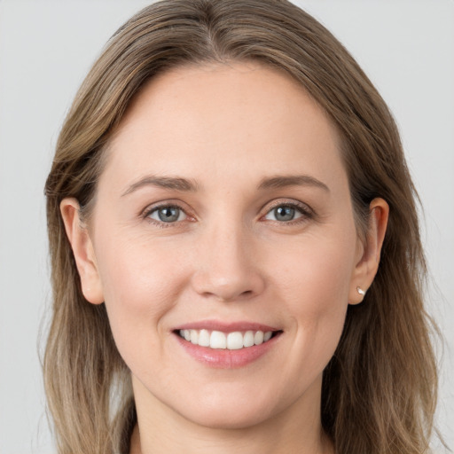 Joyful white young-adult female with long  brown hair and grey eyes