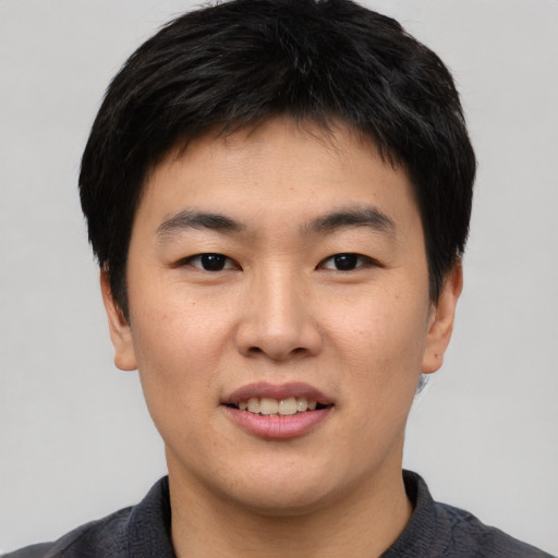 Joyful asian young-adult male with short  black hair and brown eyes