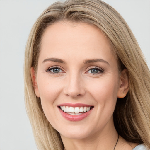 Joyful white young-adult female with long  brown hair and blue eyes