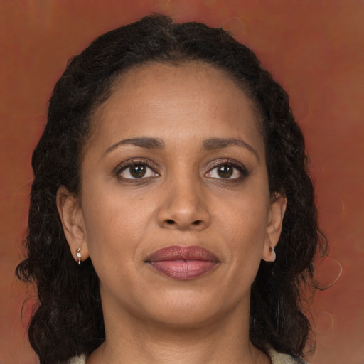 Joyful black young-adult female with long  brown hair and brown eyes