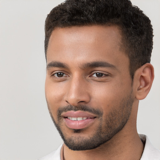 Joyful black young-adult male with short  brown hair and brown eyes