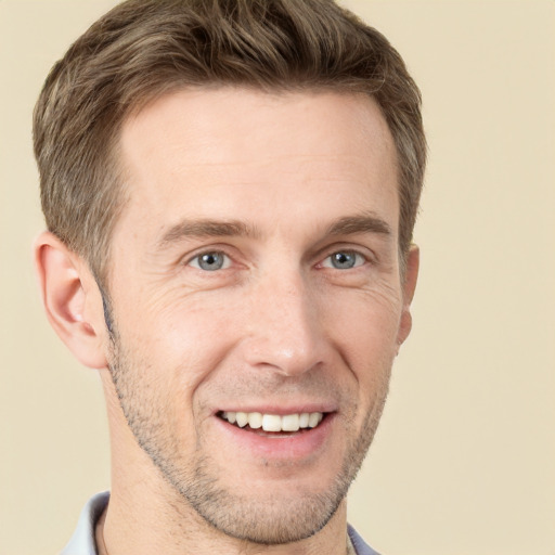 Joyful white adult male with short  brown hair and grey eyes