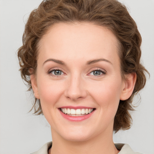 Joyful white young-adult female with medium  brown hair and green eyes