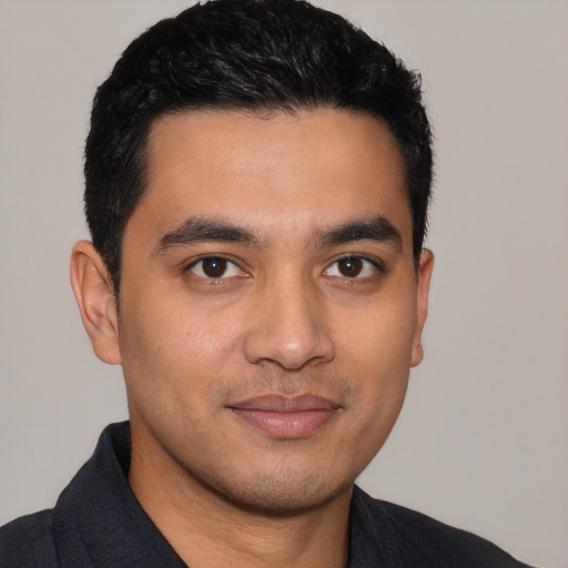 Joyful latino young-adult male with short  black hair and brown eyes